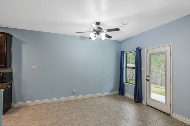 spare room with ceiling fan and a wealth of natural light