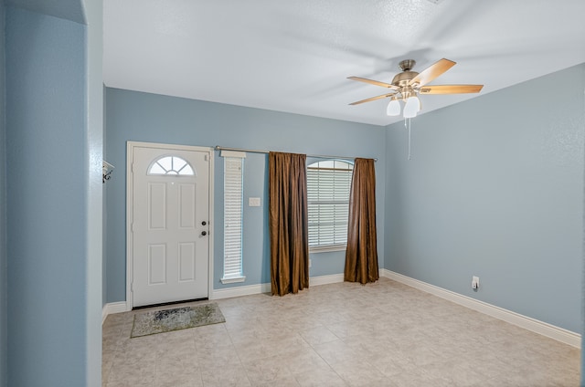 tiled entryway featuring ceiling fan and a healthy amount of sunlight