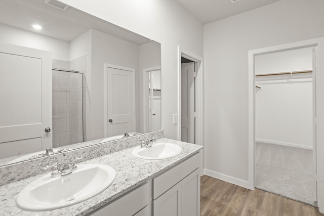 bathroom featuring wood-type flooring, an enclosed shower, and vanity