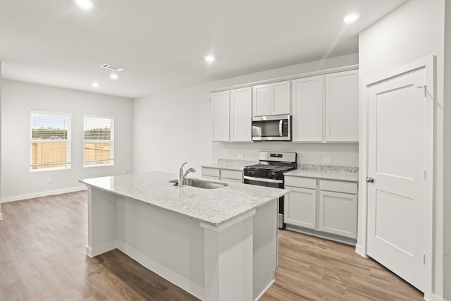 kitchen featuring sink, an island with sink, white cabinets, and appliances with stainless steel finishes