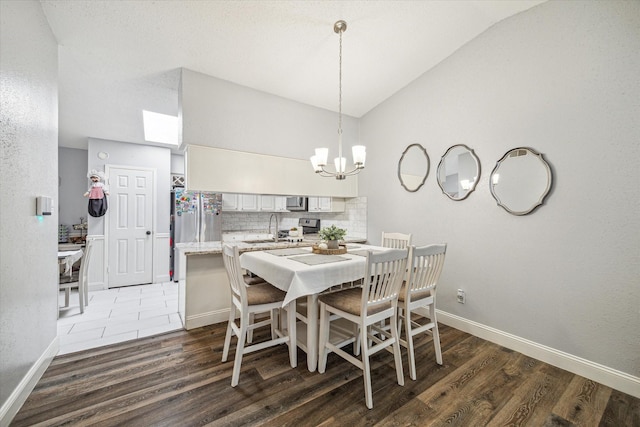 11835 Sandpiper Dr, Houston, TX 77035 - dining area with lofted ceiling, wood finished floors, a chandelier, and baseboards
