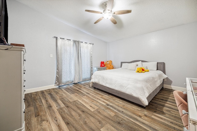 bedroom with ceiling fan, dark wood-type flooring, a textured ceiling, and lofted ceiling