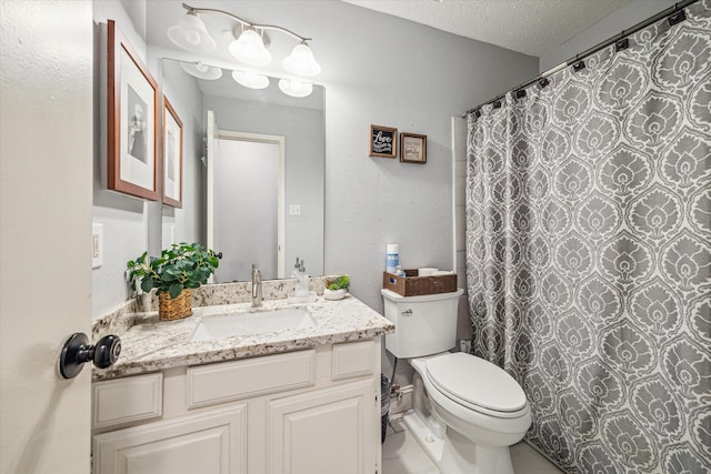 bathroom with vanity, tile patterned flooring, a textured ceiling, toilet, and walk in shower