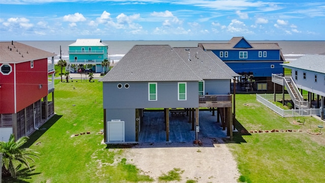 rear view of house with a yard and a deck with water view