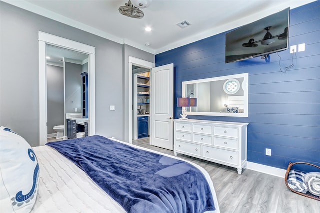 bedroom featuring light hardwood / wood-style flooring and ensuite bathroom