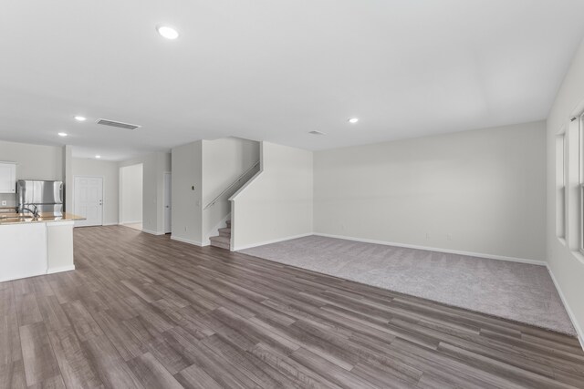 unfurnished living room with hardwood / wood-style floors and sink