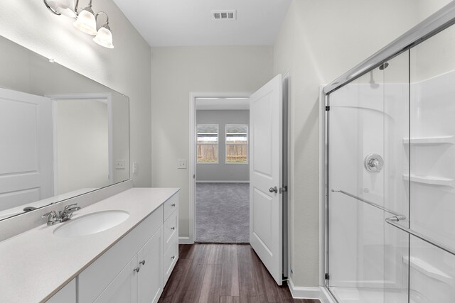 bathroom featuring a shower with door, wood-type flooring, and vanity