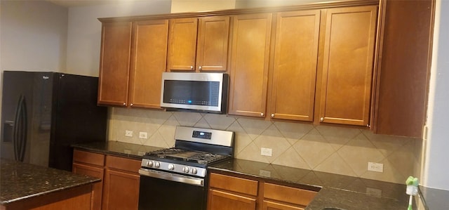 kitchen with tasteful backsplash, stainless steel appliances, and dark stone counters