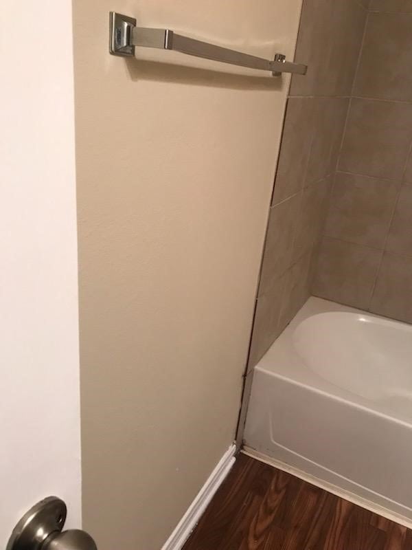 bathroom featuring tiled shower / bath combo and wood-type flooring