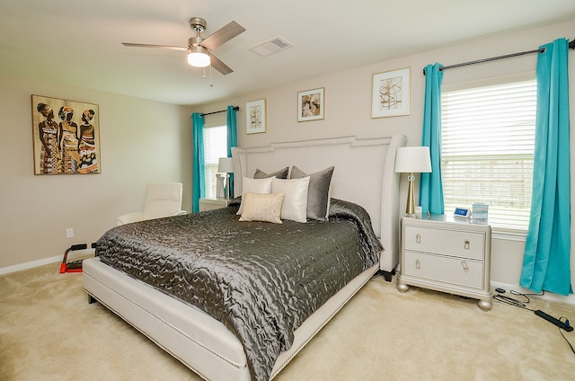 carpeted bedroom with multiple windows and ceiling fan