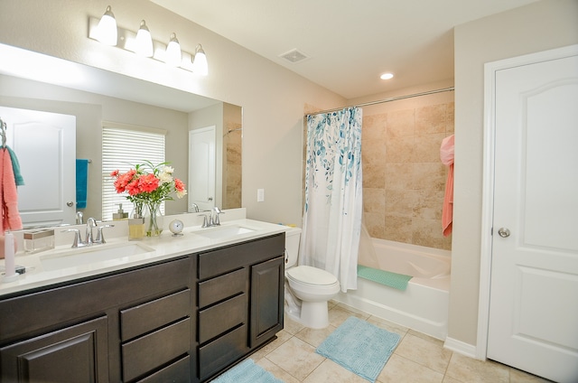 full bathroom with shower / tub combo with curtain, tile patterned floors, vanity, and toilet