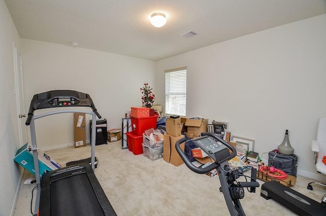 exercise room with visible vents, carpet floors, and baseboards