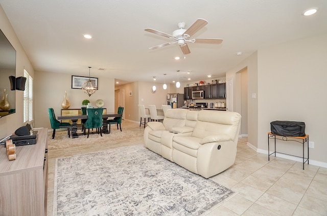 tiled living room featuring ceiling fan with notable chandelier