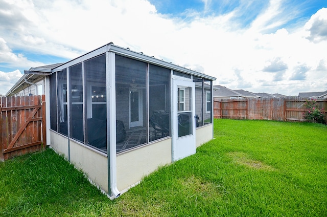 view of property exterior with a sunroom and a lawn