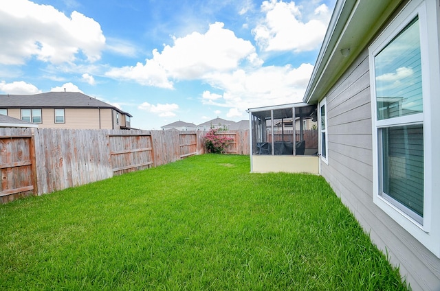 view of yard featuring a fenced backyard and a sunroom