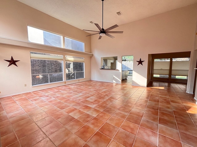 unfurnished living room with a textured ceiling, high vaulted ceiling, ceiling fan, and tile patterned floors