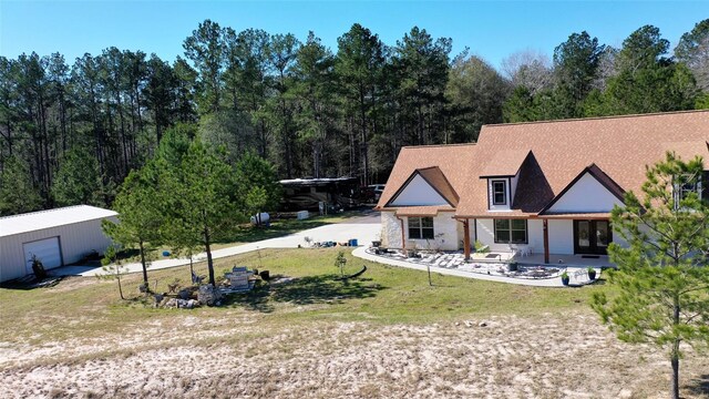 rear view of property with a garage and an outdoor structure