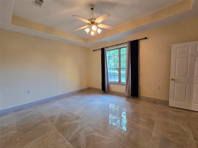 empty room with a tray ceiling and ceiling fan