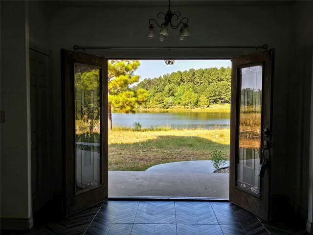 entryway featuring parquet floors, a chandelier, and a water view