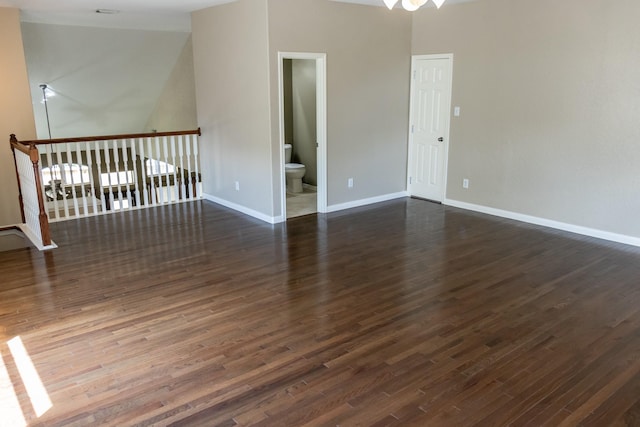 spare room featuring dark wood-style flooring and baseboards