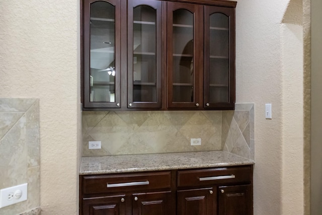 bar featuring decorative backsplash and a textured wall