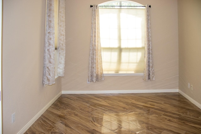 empty room with baseboards and wood finished floors