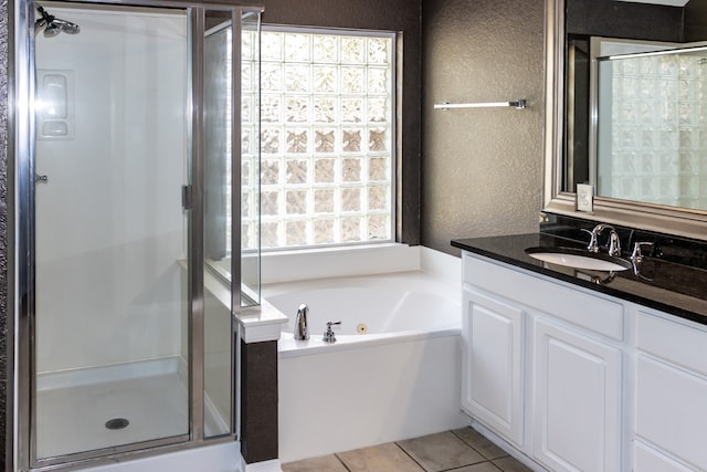 bathroom with tile patterned flooring, independent shower and bath, plenty of natural light, and vanity