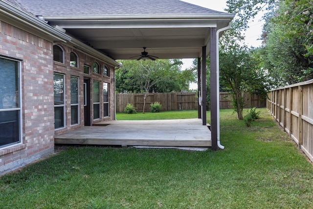 view of yard featuring a deck, a fenced backyard, and a ceiling fan