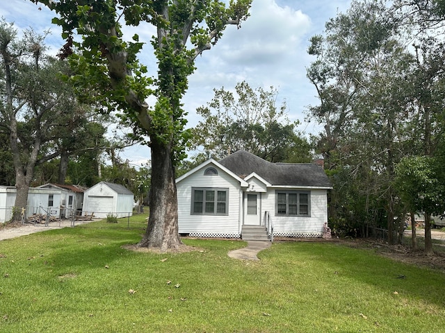 view of front facade featuring an outbuilding, a front yard, and a garage