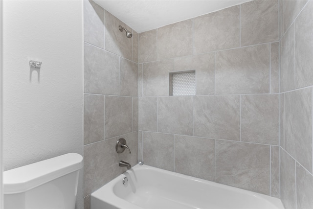 bathroom with tiled shower / bath and toilet