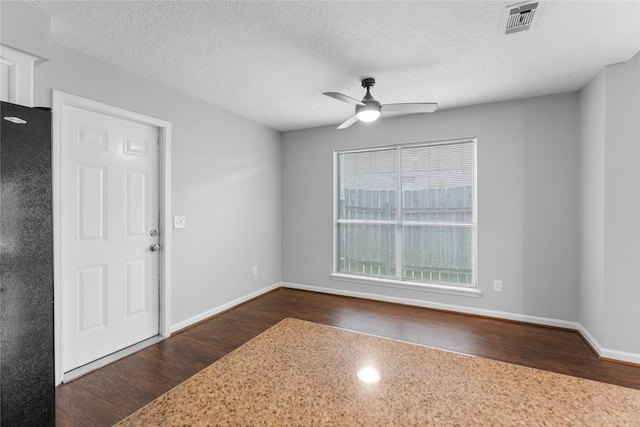 foyer entrance featuring ceiling fan, dark hardwood / wood-style floors, and a textured ceiling