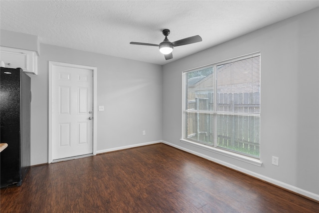 unfurnished room with ceiling fan, a textured ceiling, and dark hardwood / wood-style flooring