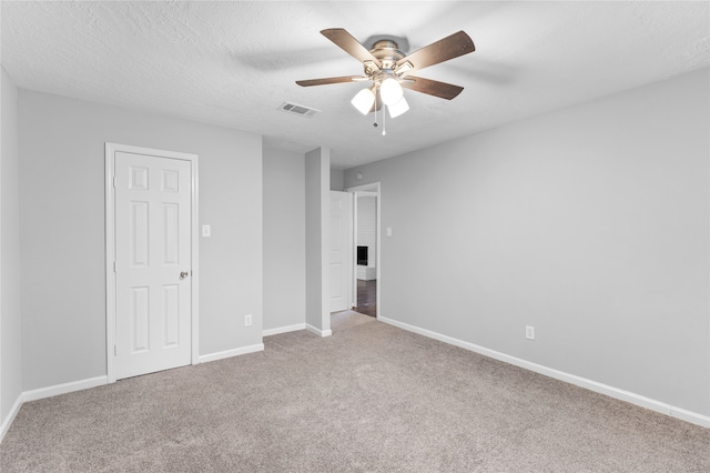 unfurnished bedroom featuring a textured ceiling, carpet flooring, and ceiling fan