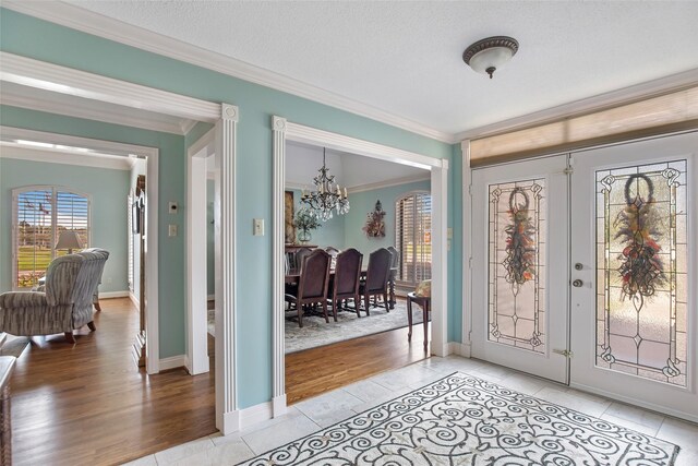 611 S Cleveland St, Dayton, TX 77535 - entrance foyer featuring a chandelier, ornamental molding, french doors, and light wood-type flooring