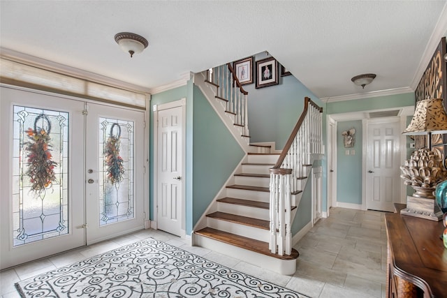 foyer featuring ornamental molding, a textured ceiling, a healthy amount of sunlight, and light tile patterned floors