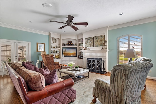 living room featuring light hardwood / wood-style flooring, a textured ceiling, ceiling fan, and crown molding