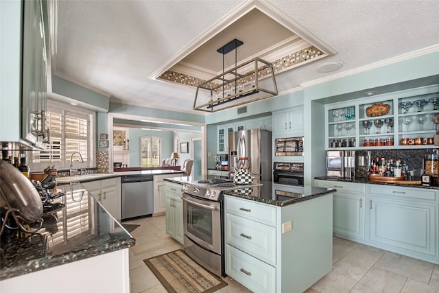 kitchen featuring hanging light fixtures, sink, a center island, appliances with stainless steel finishes, and a textured ceiling