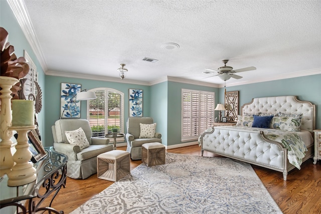 bedroom with ornamental molding, hardwood / wood-style flooring, a textured ceiling, and ceiling fan