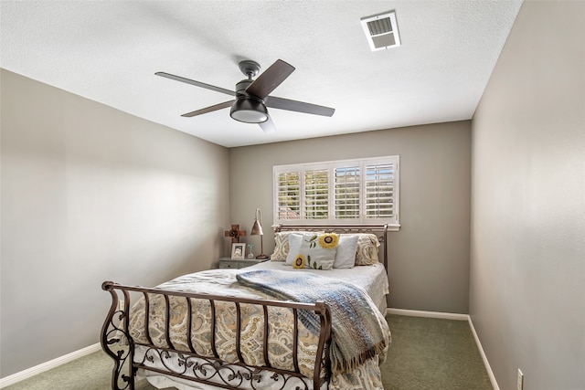 carpeted bedroom featuring ceiling fan and a textured ceiling