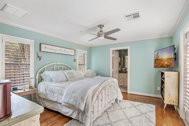 bedroom with ceiling fan, crown molding, ensuite bath, and hardwood / wood-style floors