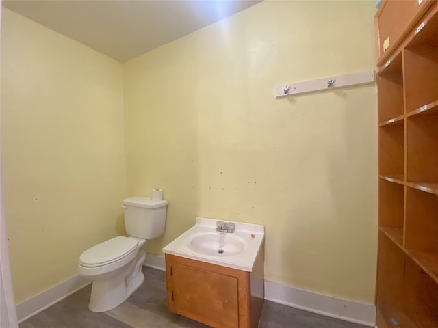 bathroom with hardwood / wood-style flooring, vanity, and toilet