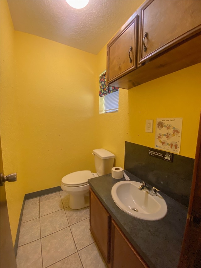 bathroom with tile patterned floors, a textured ceiling, vanity, and toilet