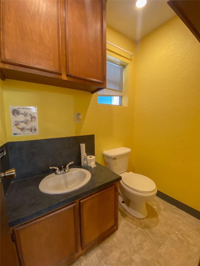 bathroom featuring tile patterned flooring, vanity, and toilet