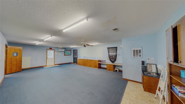 misc room with ceiling fan, carpet, a textured ceiling, and a wall unit AC