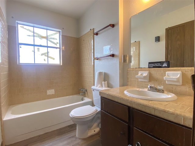 full bathroom with hardwood / wood-style flooring, decorative backsplash, vanity, tile walls, and toilet