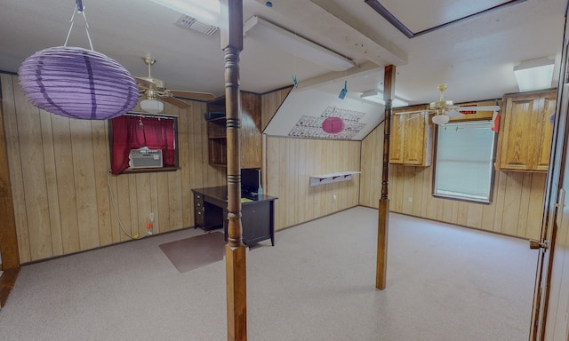 basement with wooden walls, ceiling fan, cooling unit, and light colored carpet