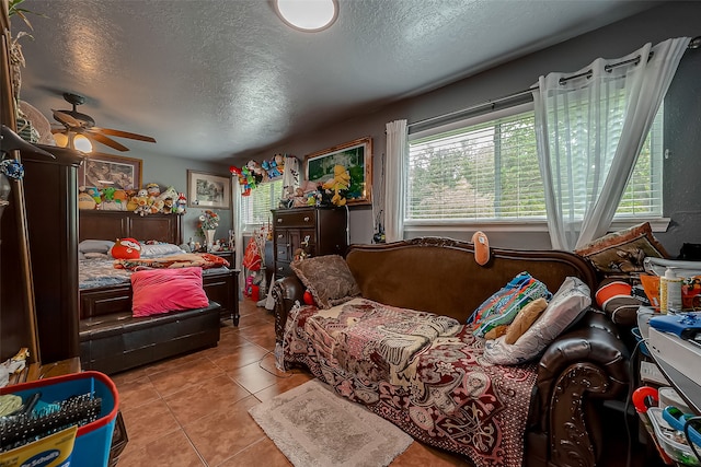 tiled bedroom with a textured ceiling and ceiling fan