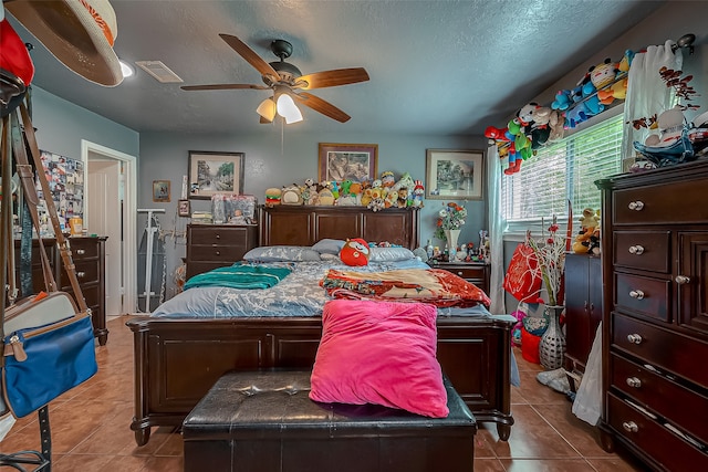 bedroom with ceiling fan, a textured ceiling, and light tile patterned floors