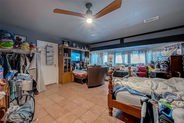 tiled bedroom featuring ceiling fan