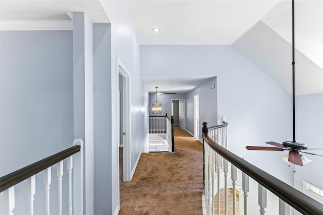 corridor featuring crown molding, carpet floors, lofted ceiling, and an inviting chandelier